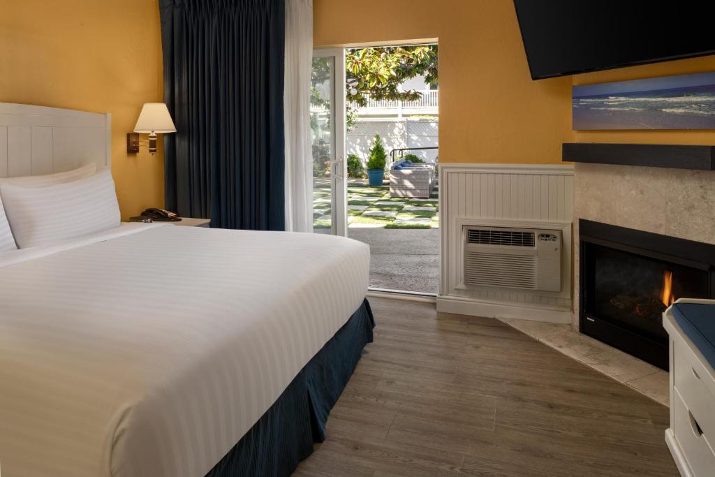 a hotel room with a bed and a fireplace at Monterey Bay Lodge in Monterey