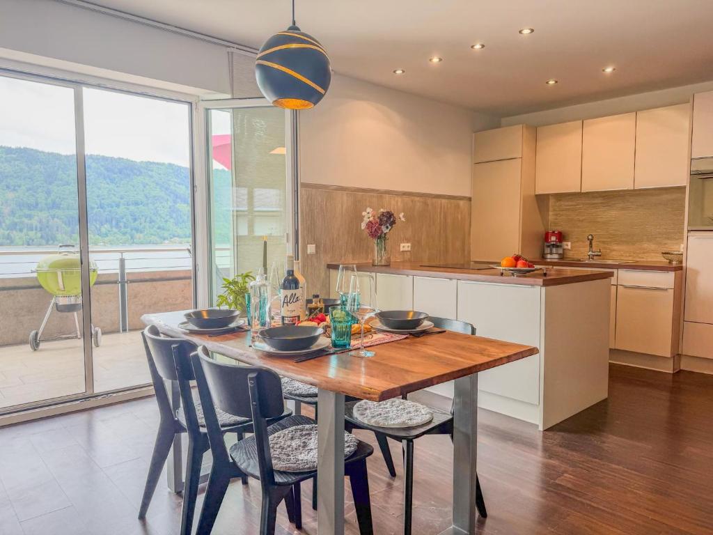 a kitchen with a wooden table and chairs with a view at Apartment Franz in Sattendorf