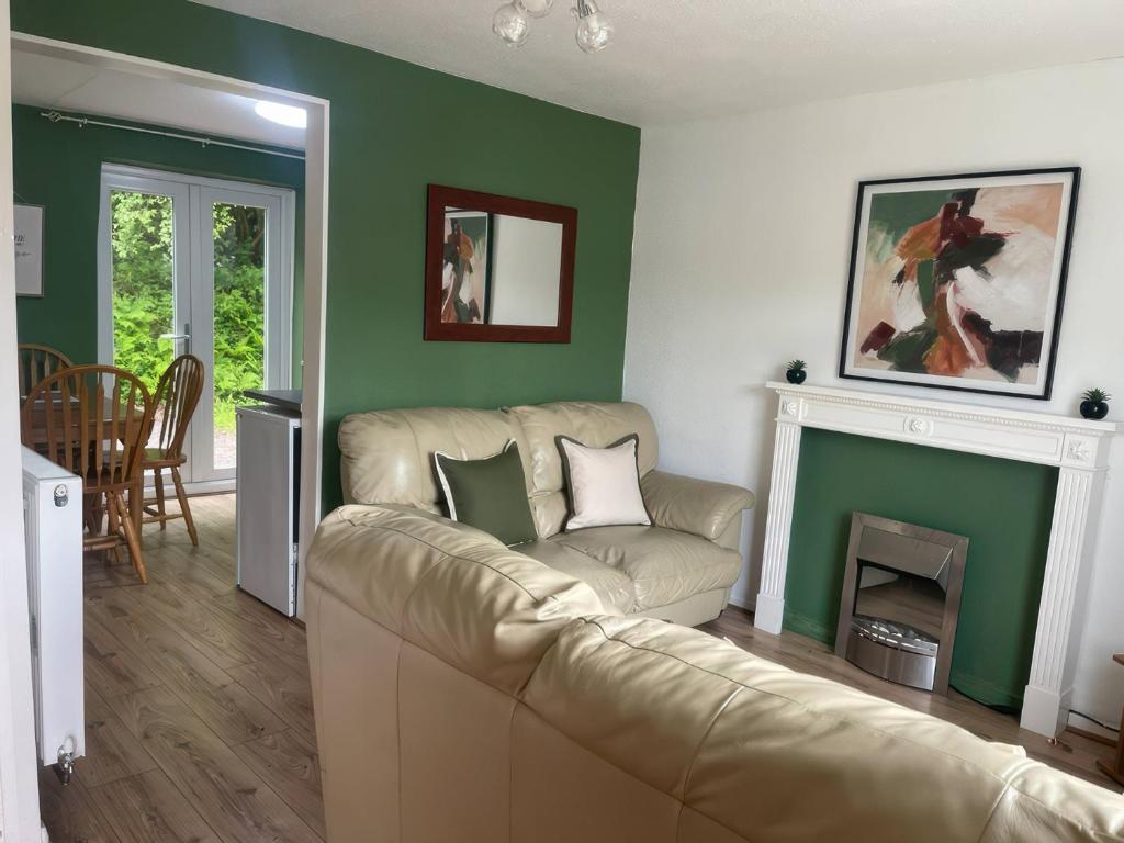 a living room with a couch and a fireplace at Eirlys in Caernarfon