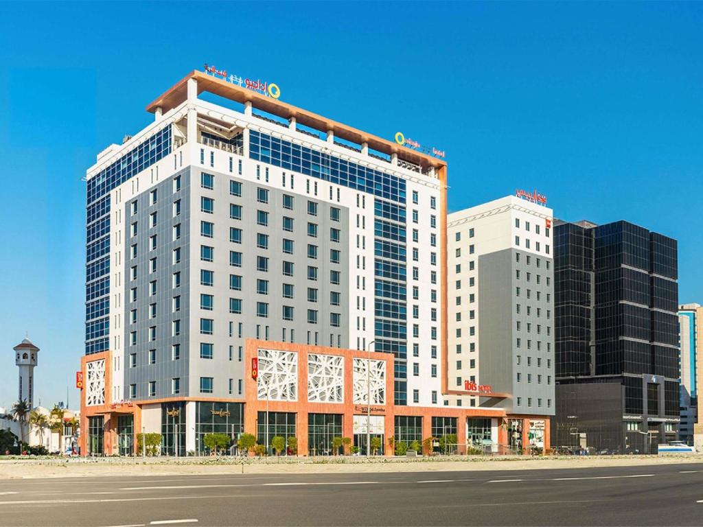 a tall white building on the side of a street at Adagio Jeddah City Center in Jeddah