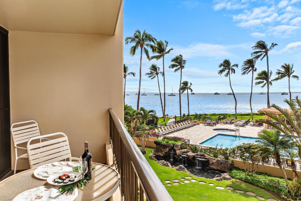 a balcony with a table and chairs and a view of the ocean at Sugar Beach 304 in Kihei