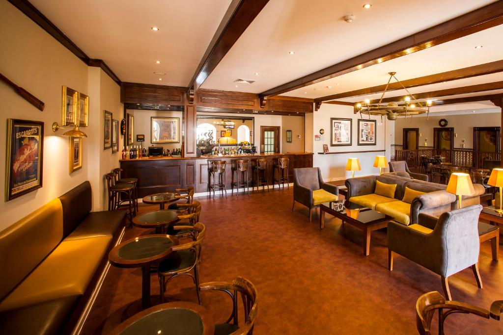 a hotel lobby with couches and tables and a bar at Vila Gale Ericeira in Ericeira