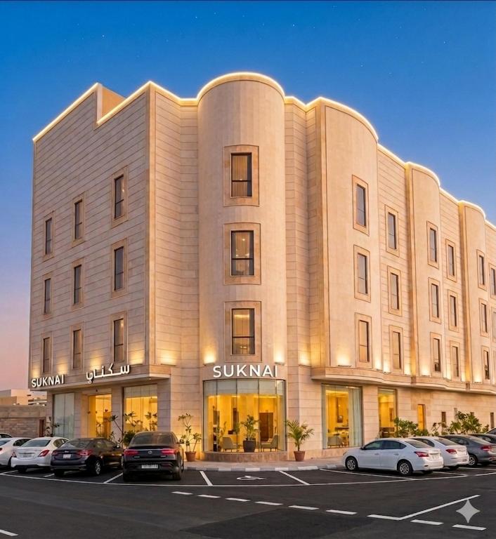 a large building with cars parked in a parking lot at سكناي الياسمين للشقق المخدومة - Suknai Al Yasmin Serviced Apartments in Hail