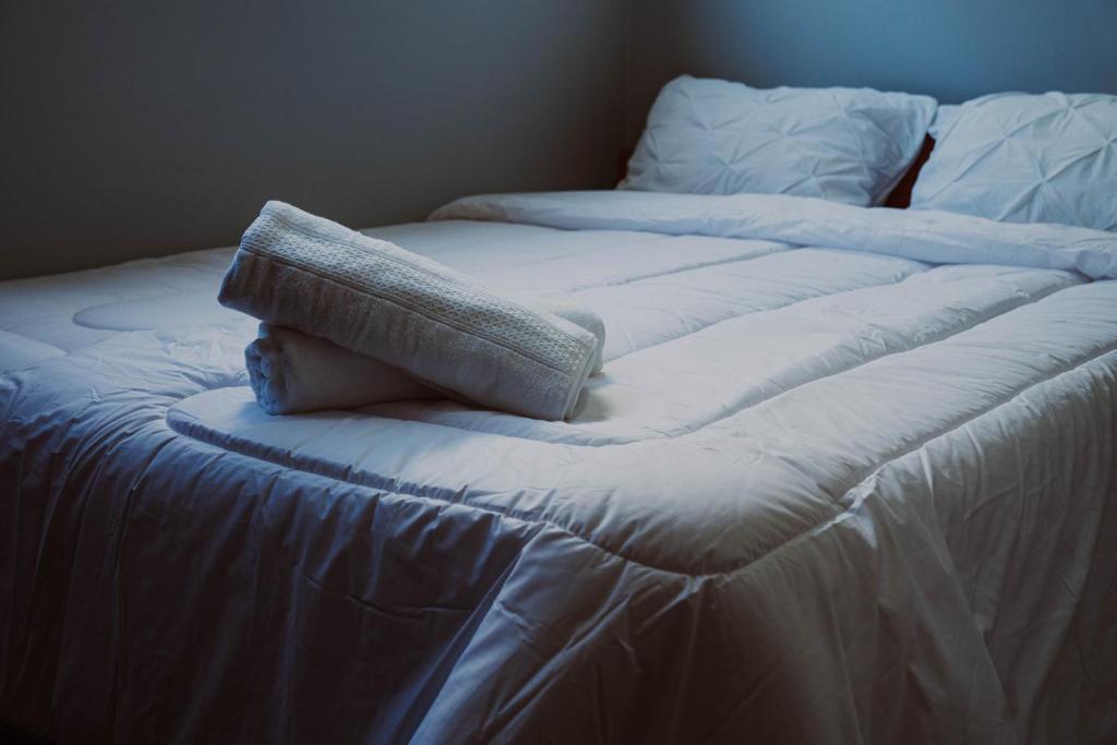 two unmade beds with a pillow on top of them at HoTELBLU in Santiago