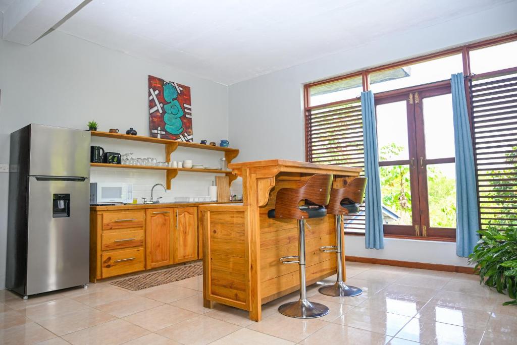 a kitchen with wooden cabinets and a stainless steel refrigerator at Hidden Secret in Gros Islet