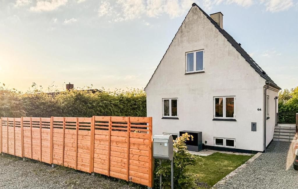a white house with an orange fence at 2 Bedroom Awesome Home In Faaborg in Faaborg