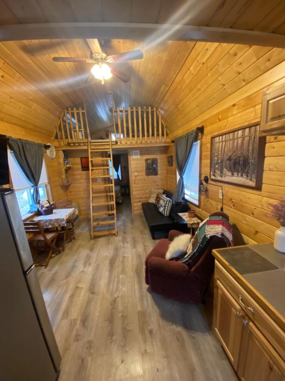 a living room with a couch and a staircase in a tiny house at Ak backcountry retreat in Kenai