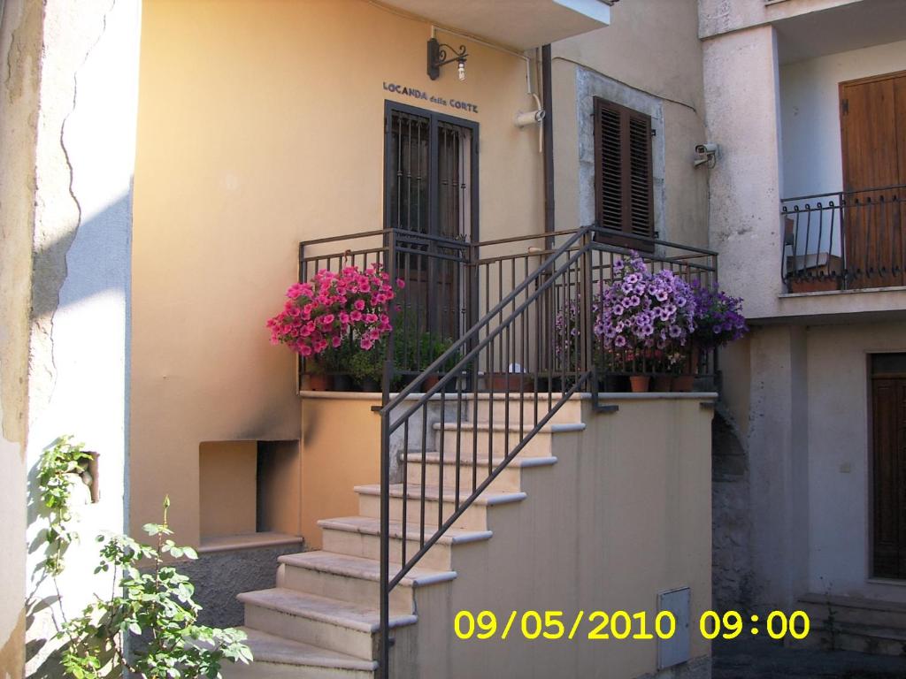 un escalier avec des fleurs sur le côté du bâtiment dans l'établissement Locanda della Corte, à Roccamorice