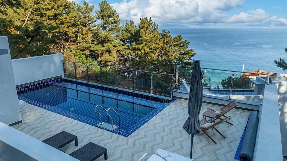 a swimming pool on top of a house with the ocean at Yeongdeok Full Moon Pool Villa in Yŏngdŏk