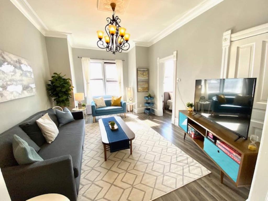 a living room with a couch and a flat screen tv at Walk to Wrigley 3BR1BA Sleeps 8 Free Parking in Chicago
