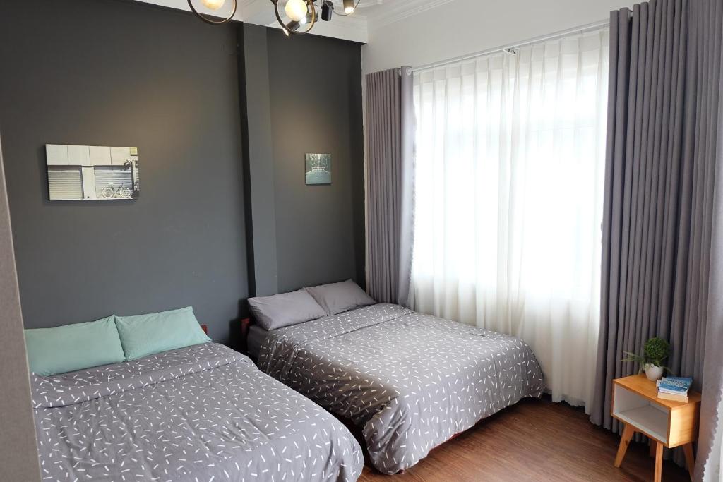 a bedroom with two beds next to a window at Villa Aqua Da Lat in Da Lat