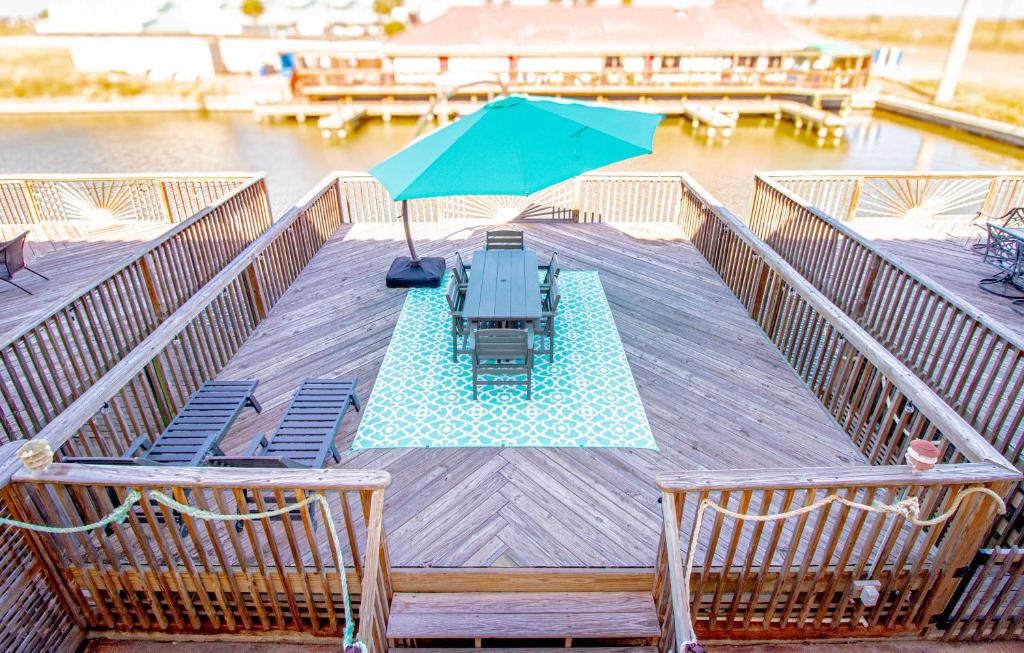 a pool with chairs and an umbrella on a deck at La Sirena Pescadora in Corpus Christi
