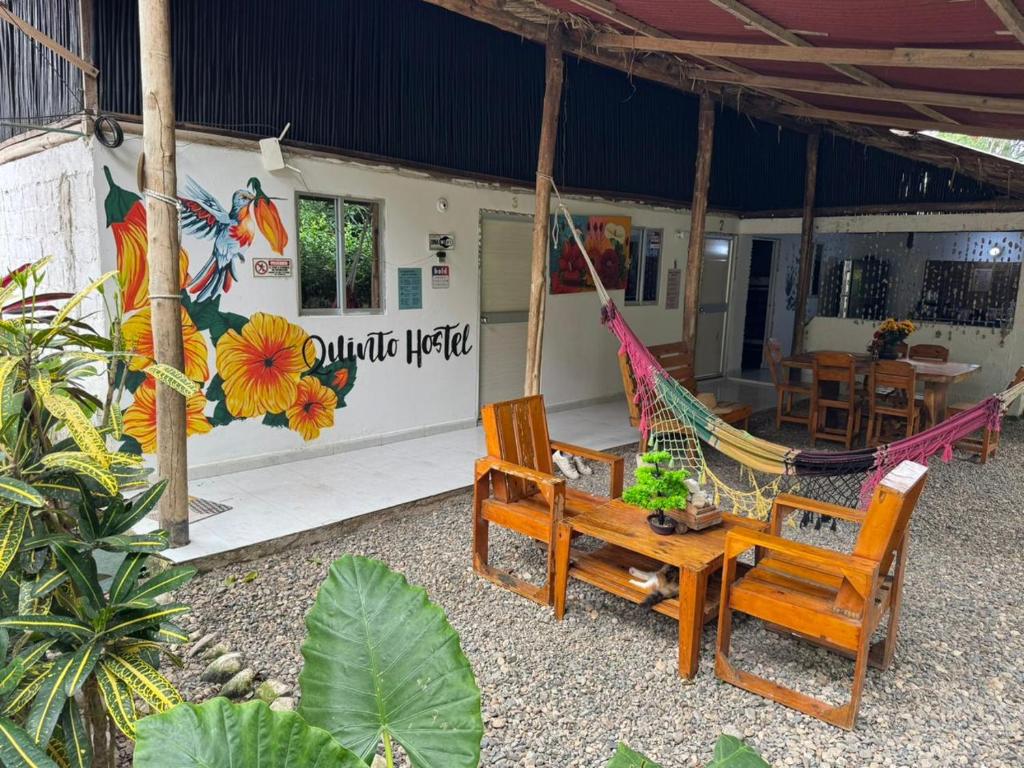 a resort with a hammock and a table and chairs at Quinto Hotel in Palomino