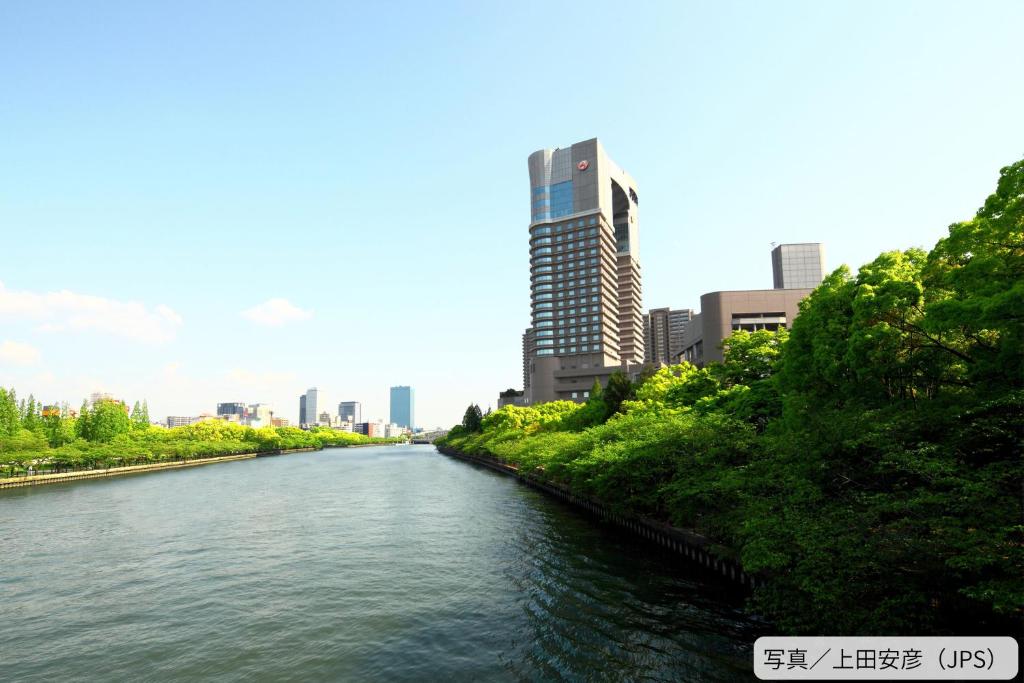 a river in a city with a tall building at Imperial Hotel Osaka in Osaka