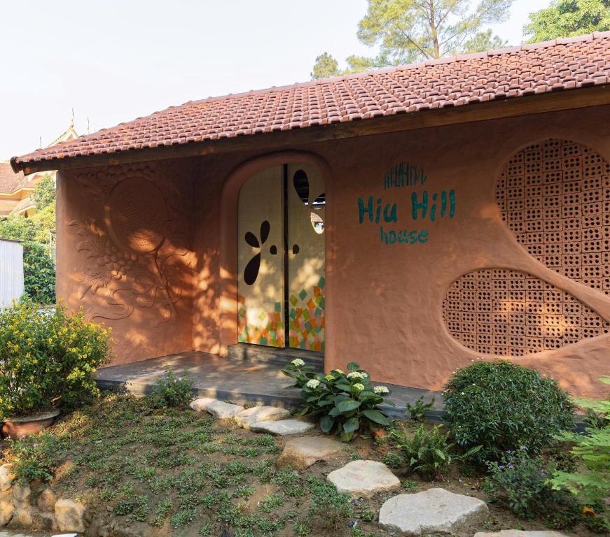 a small house with a door with writing on it at HiuHill House in Cồn Giả Viên
