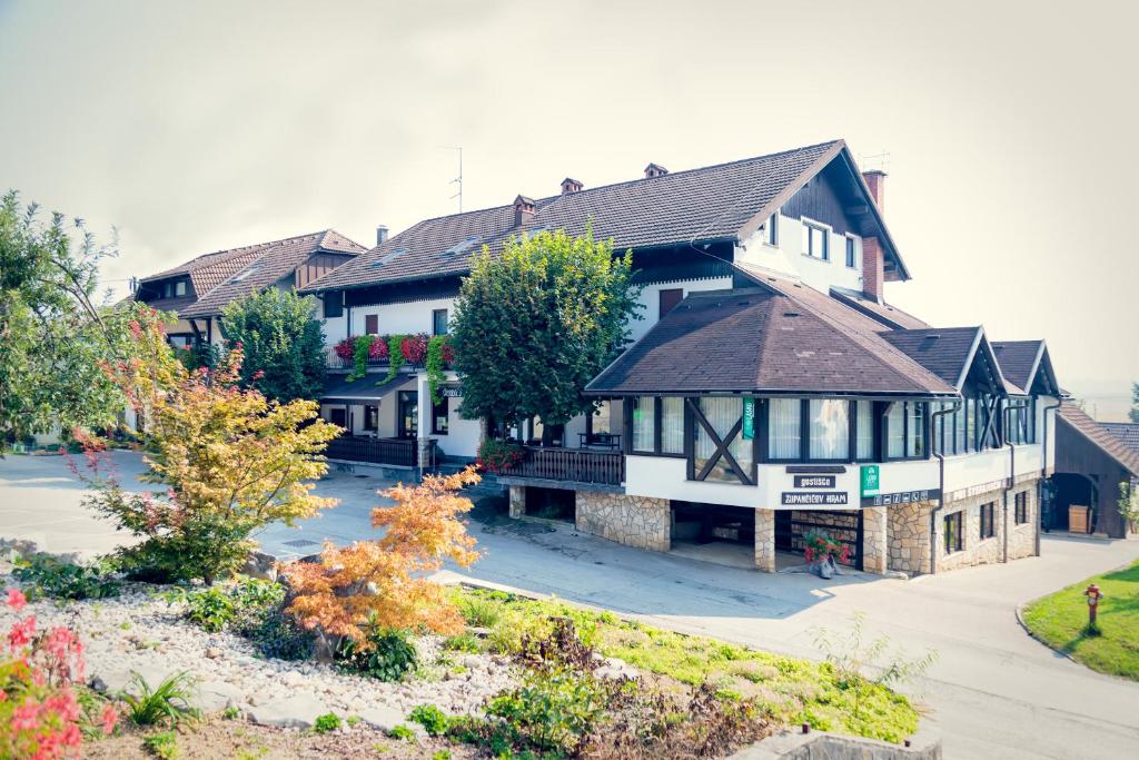 a large white house with a black roof at Župančičev hram in Dragatuš