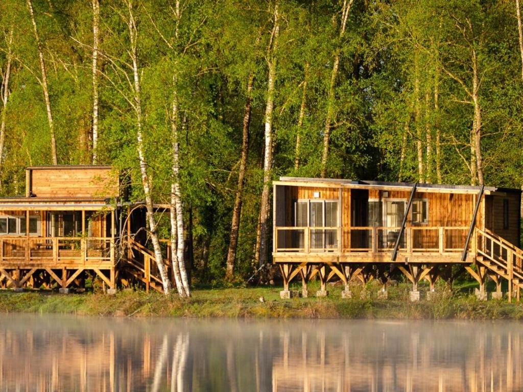 a couple of houses on the shore of a lake at Chalet avec animaux admis - 4 pers. - API-1-52-2772 in Sainte-Montaine