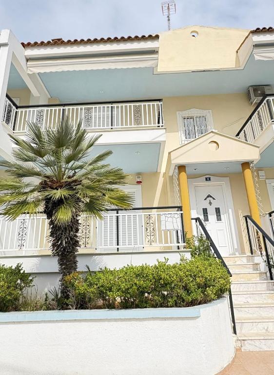 a house with a palm tree in front of it at Seaside Apartment in Vrachati