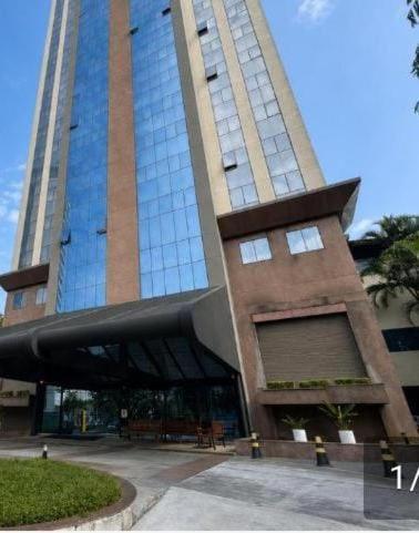 a large tall building with a glass facade at MN Gotado Hotel Flat Guarulhos Aeroporto in Guarulhos