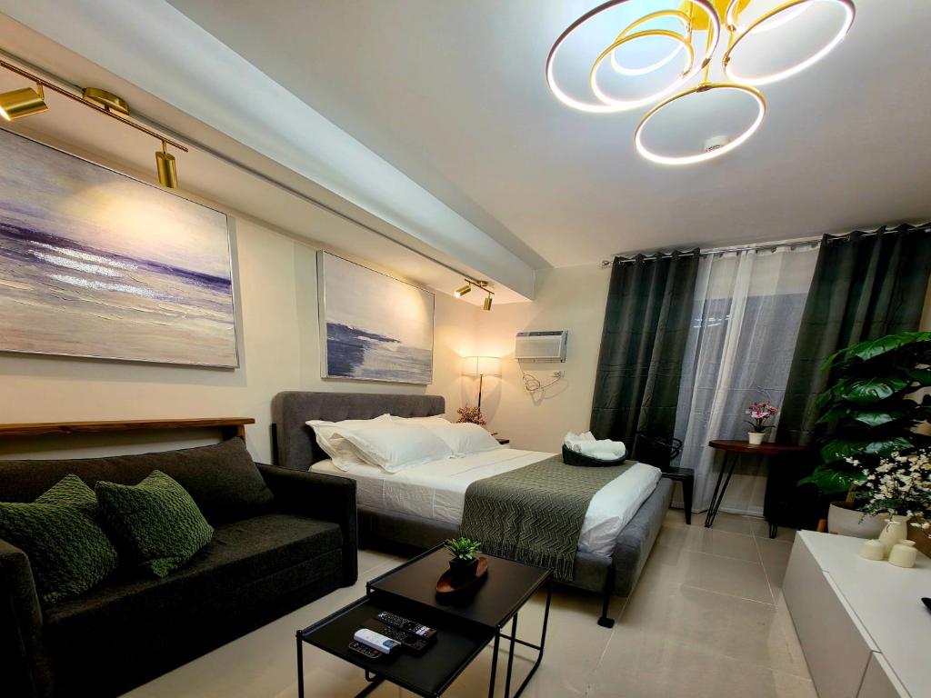 a hotel room with a bed and a couch at The View at 34th - Sunset Skyline Suite Near SM J Mall & Fiber Wifi in Mandaue City