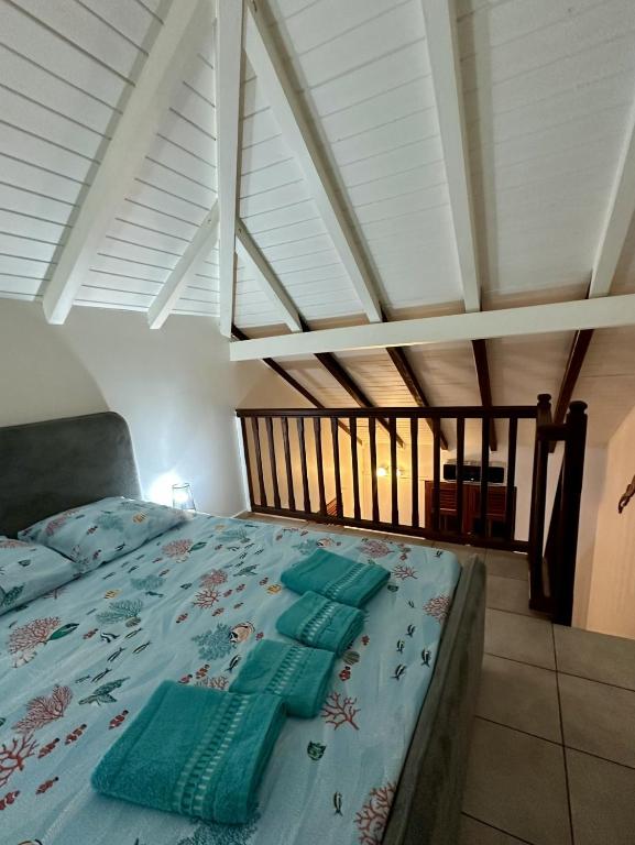 a bedroom with a bed with a blue comforter at Le Coeur des Iles in Sainte-Anne