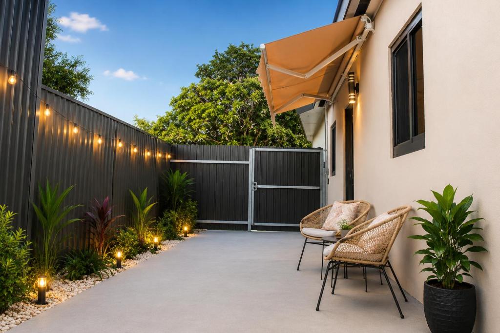 a patio with chairs and a fence with lights at MG Realty Luxury Stay in Miami