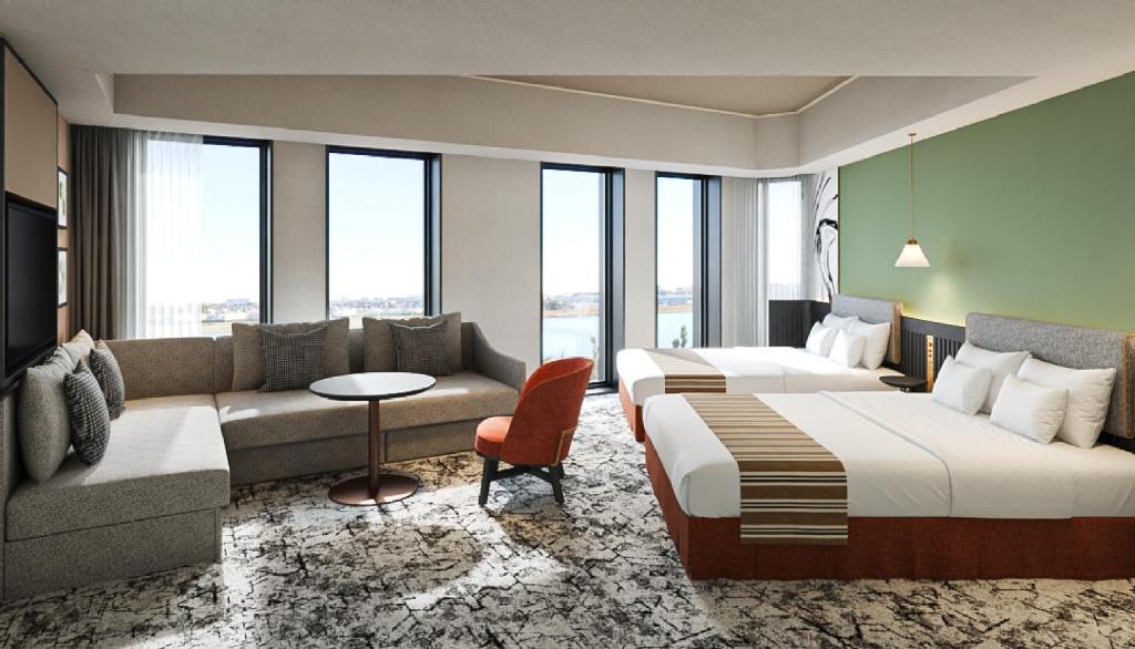 a hotel room with two beds and a couch at Premium hotel MONday MAIHAMA VIEW 2 in Tokyo