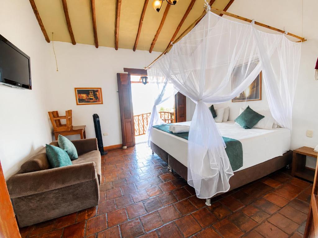 a bedroom with a bed with a mosquito net at Posada Sueños de Antonio in Barichara