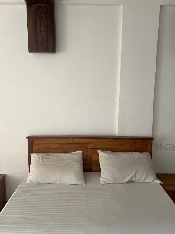 a bedroom with a bed with two white pillows at morriz inn in Kalpetta