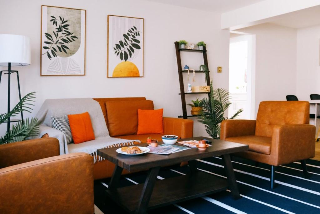 a living room with orange furniture and a coffee table at Modern Condo • Safe Chicago Stay Near O’Hare in Chicago