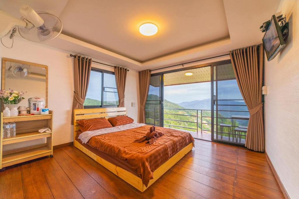 a bedroom with a bed with a dog sitting on it at Raisuayang in Mon Jam