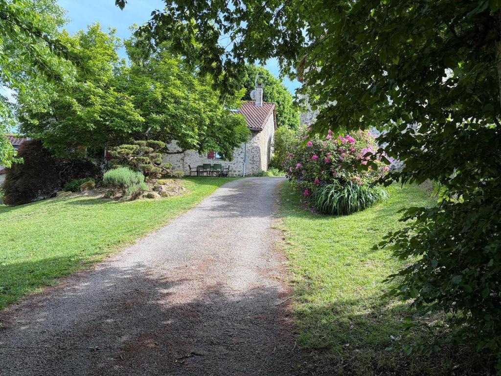 a dirt road leading to a house with flowers at Patissou in Solignac