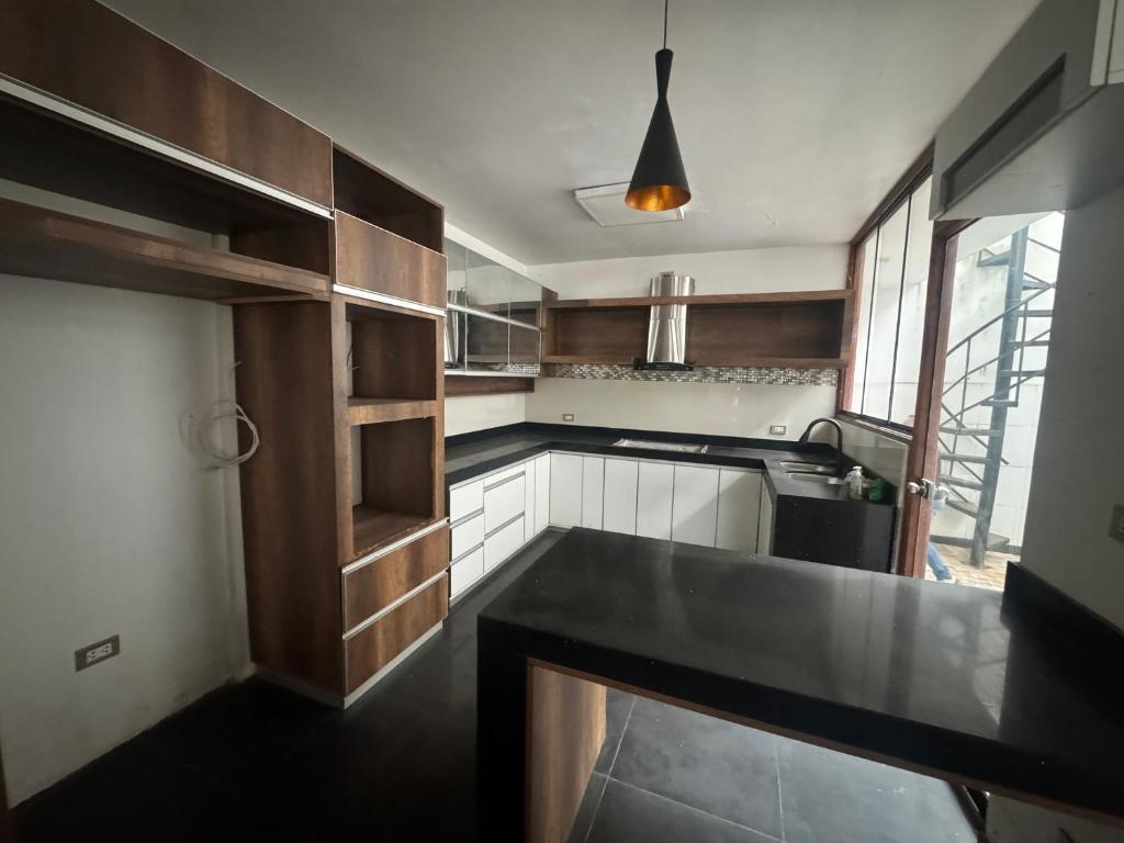 a kitchen with wooden cabinets and a black counter top at Sonrisas in Iquitos