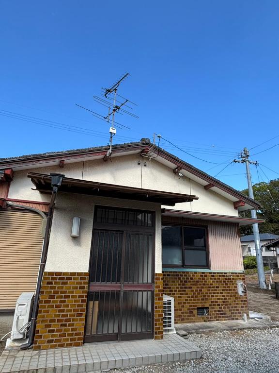 a small house with a large door on it at 黒潮の家 ドミトリー in Kuroshio