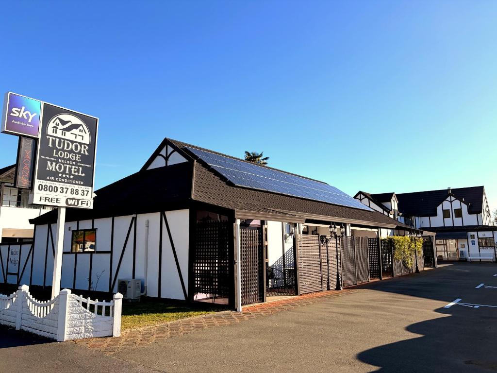 a building with a sign in front of a motel at Tudor Lodge Motel in Nelson