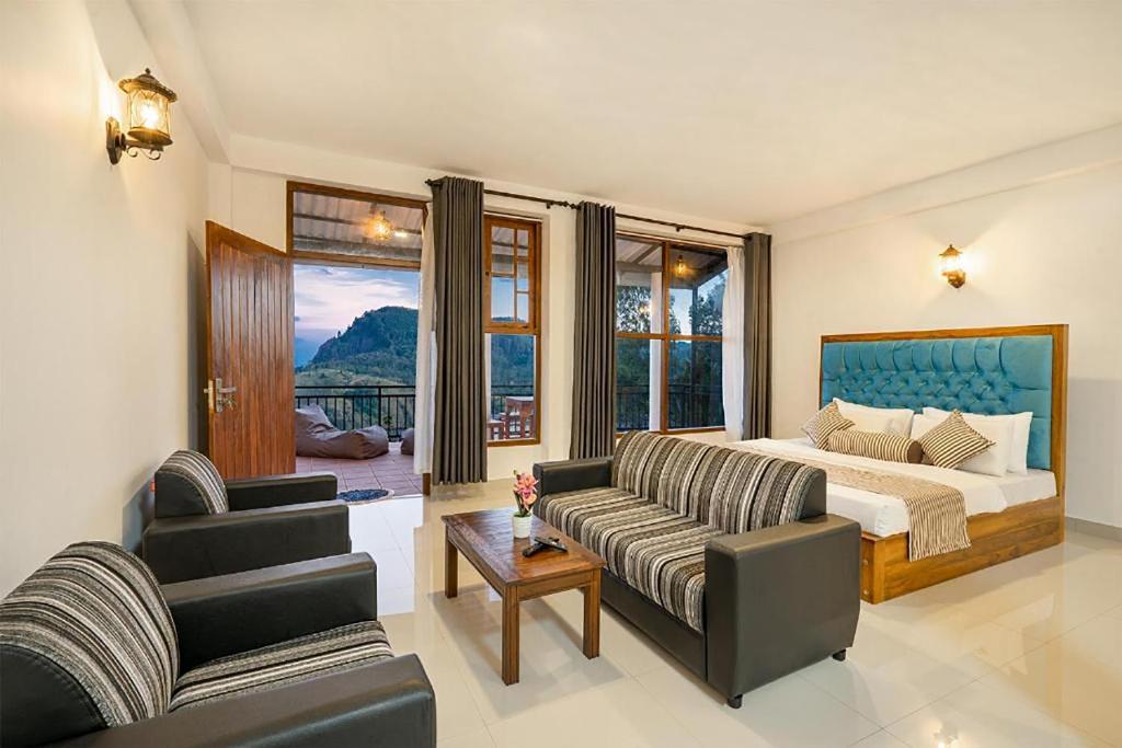 a bedroom with a bed and a couch and chairs at Ella Ostella in Ella