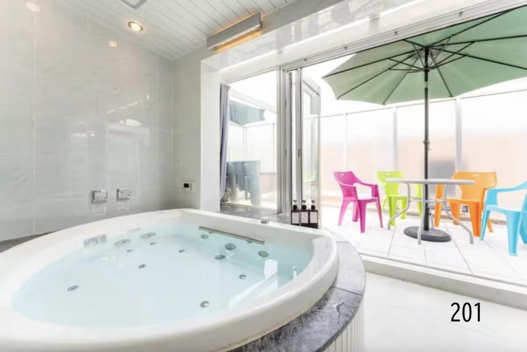 a large white bathroom with a tub and a table and chairs at Shibuya City House 渋谷シティハウス in Tokyo