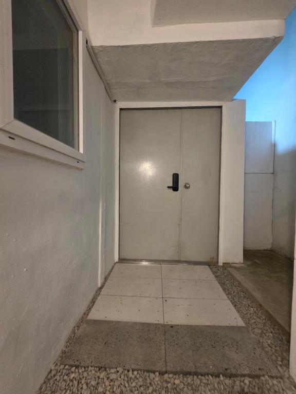 a white door in a room with a window at Stay538 in Busan