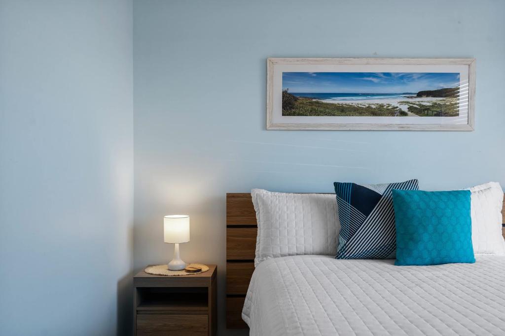 a bedroom with a bed and a picture on the wall at Oceans 13 in Manyana