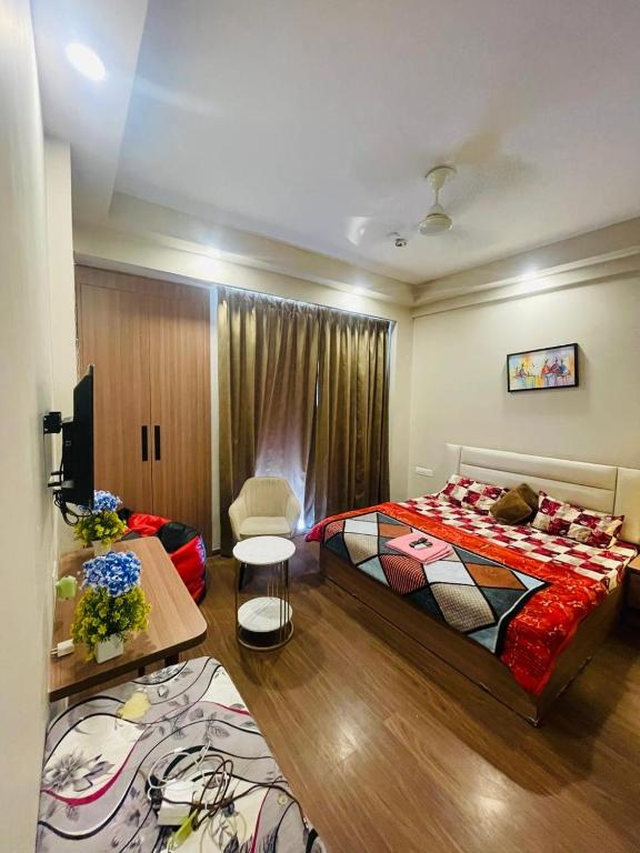 a bedroom with a bed and a chair in it at Greno luxe stays in Greater Noida