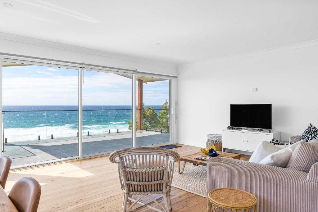 a living room with a view of the ocean at Ocean Overlook - Rennies Beach holiday haven in Ulladulla