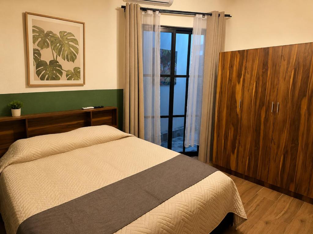 ein Schlafzimmer mit einem Bett und einer Glasschiebetür in der Unterkunft Privada Guadalupe in Monterrey