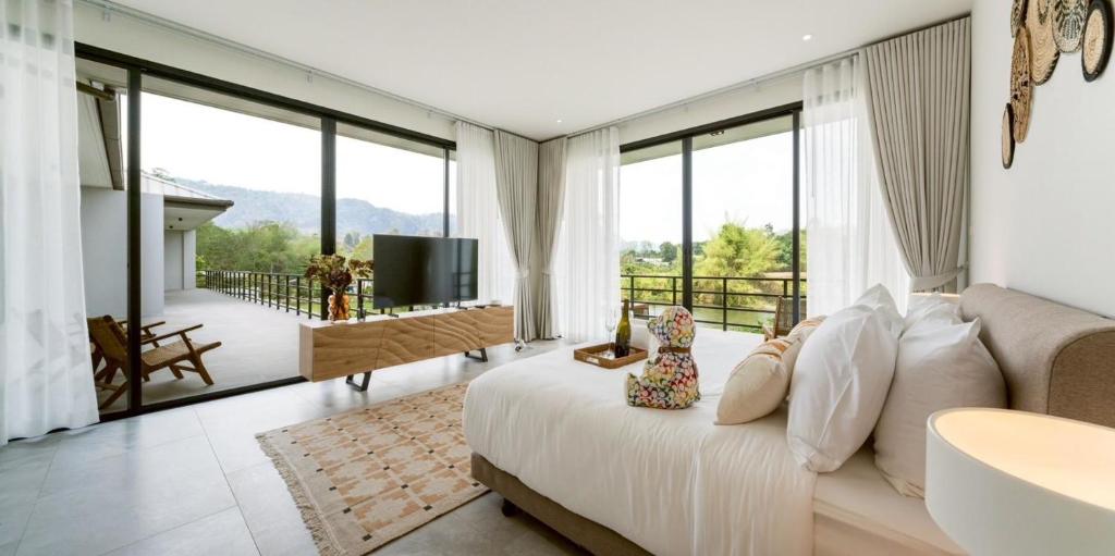 a living room with a bed and a television at Rivendale in Ban Gaeng Cho