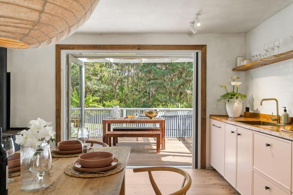 a kitchen with a table and a dining room at Coastal Soul in Narrawallee