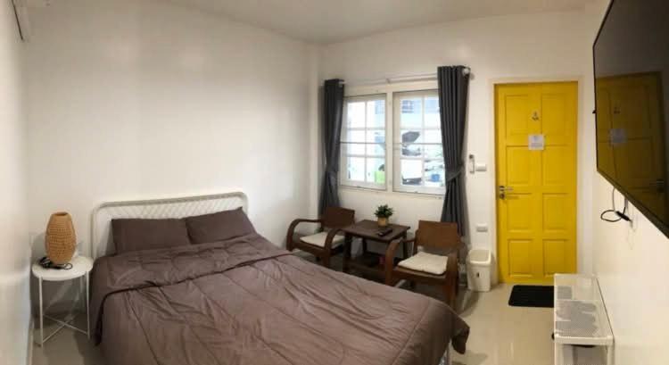 a bedroom with a bed and a yellow door at Homestay Laksi in Lak Si