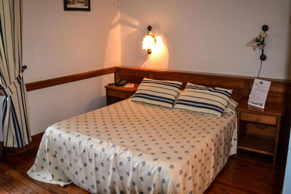 a bedroom with a bed with two pillows on it at Grand Hôtel de France in Pierrefitte-Nestalas