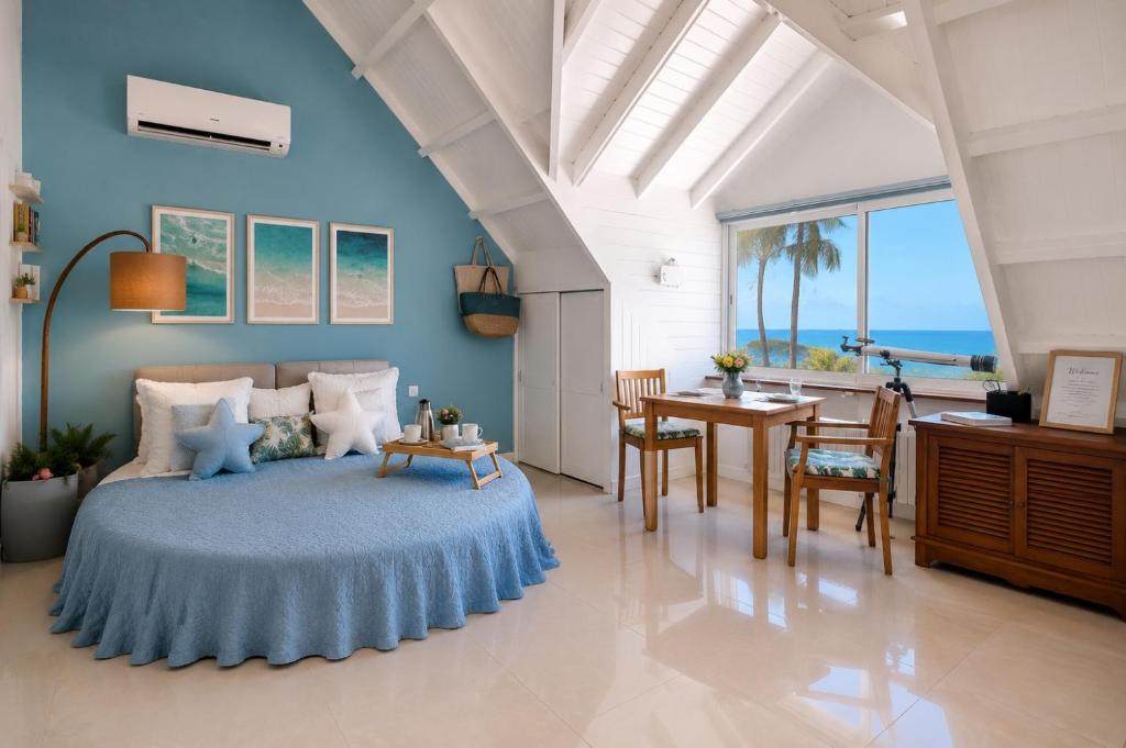a bedroom with a bed and a table and chairs at Deja Blue - Comfortable Beachfront condo in Marigot