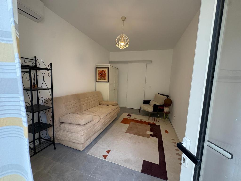 a living room with a couch and a table at Studio en maison historique in Golfe-Juan