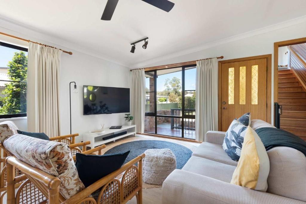 a living room with a couch and a tv at Barker Retreat in Burrill Lake