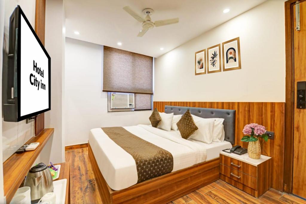 a bedroom with a bed and a flat screen tv at Hotel Aerotech Near Delhi Airport in New Delhi